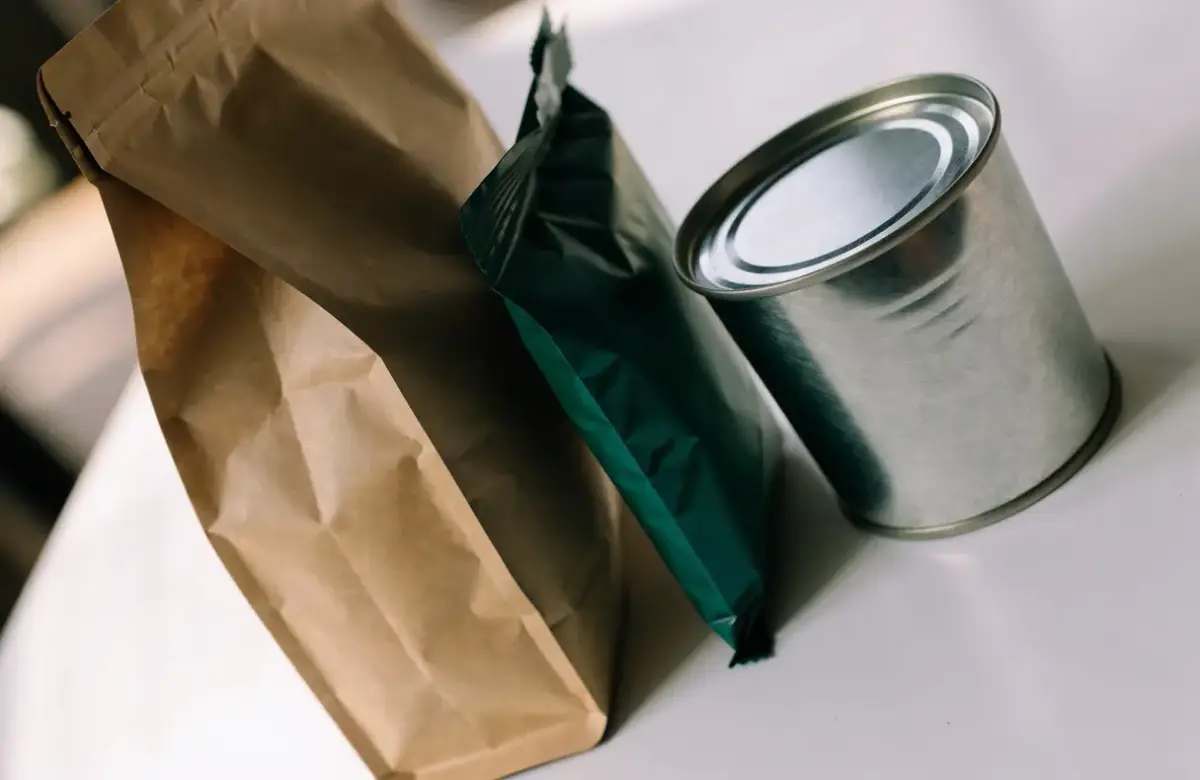 Verpackungsarten 2 Papierbeutel, flacher Folienbeutel und Weißblechdose nebeneinander als Beispiele für Verkaufseinheiten